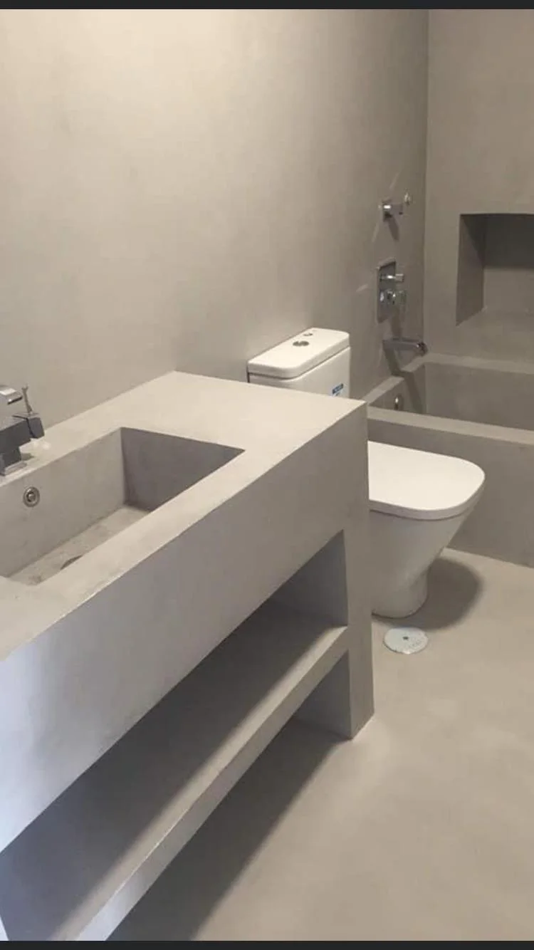 Baño con bañera y lavabo de obra en microcemento